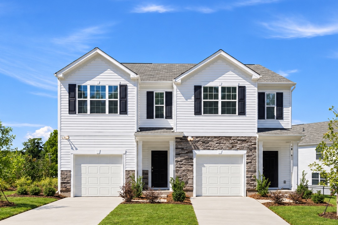 Hubbard two-story townhomes with white siding, stone accents, and attached garages